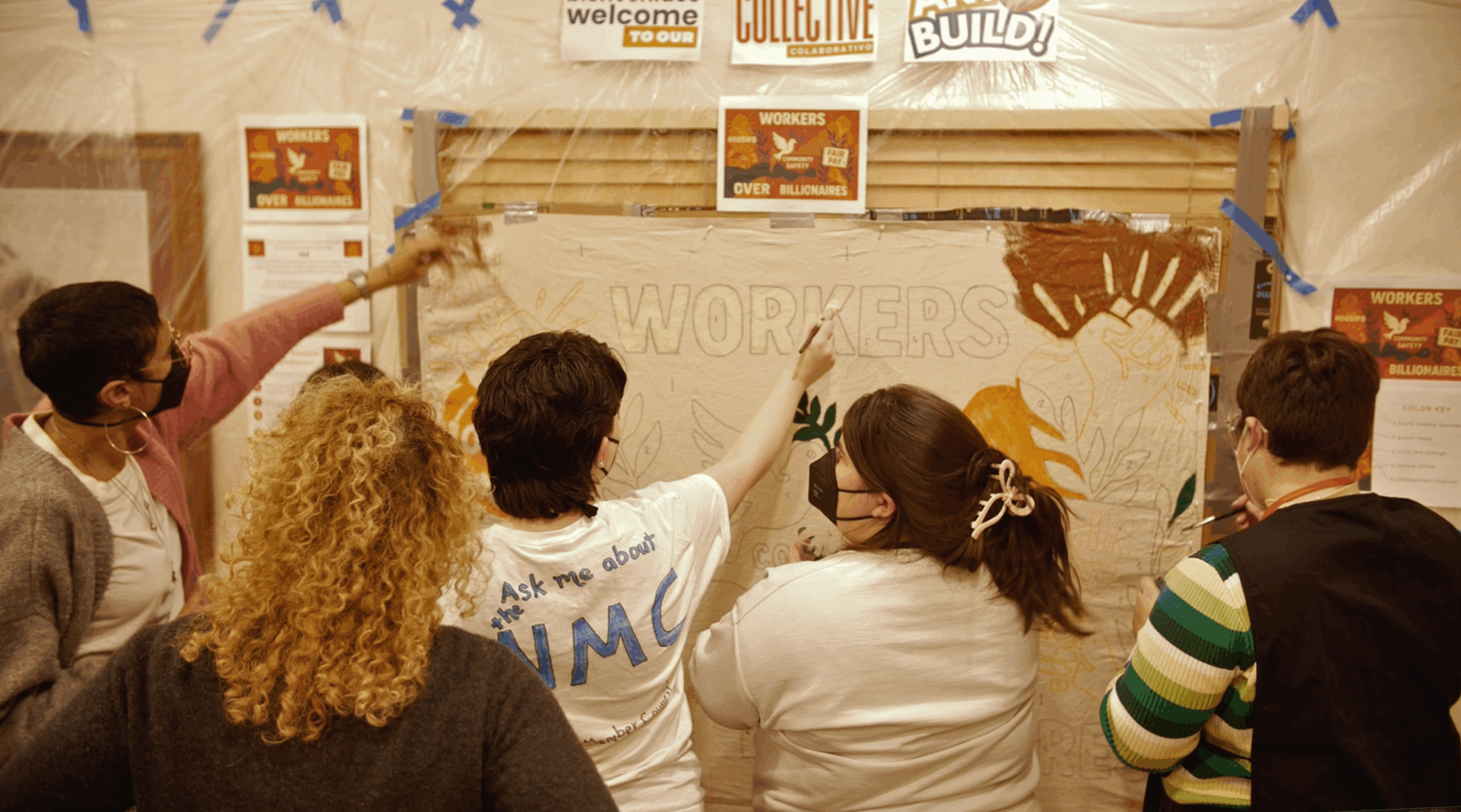 Conference attendees and Resource Generation members paint a campaign poster together at the 2025 MMMC conference in Santa Fe, capturing a moment of collective creativity and shared political vision. Photo by Doza, Ditch the Box Studios.